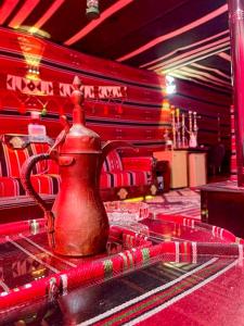 a red tea kettle sitting on top of a table at Petra fort hotel in Wadi Musa