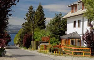 a white building with a sign next to a street at HOTEL LE CHARME con parking in San Carlos de Bariloche