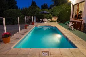 una pequeña piscina con mesa y sombrilla en HOTEL LE CHARME con parking en San Carlos de Bariloche