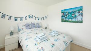 a white bedroom with a bed with towels on it at Wee Jules By The Sea in Anstruther