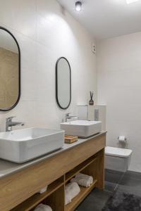 a bathroom with two sinks and a mirror at Sea On Mamaia in Mamaia +29 photos