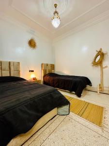 1 dormitorio con 2 camas y lámpara de araña en K11SURF, en Aourir