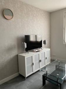 - un salon avec une télévision sur un meuble blanc dans l'établissement Joli studio avec parking privé, bien situé, à Moulins
