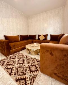 a living room with a brown couch and a table at K11SURF in Aourir