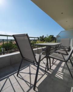 a table and chairs sitting on a balcony at Masticha Apartment in Oinófita
