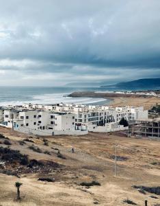 a group of white buildings on top of a beach at K11SURF in Aourir