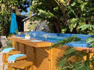 a wooden table with chairs and a swimming pool at 3Gulls Inn Ozona-Boutique Hotel-Steps from Restaurants & Brewery-SwimSpa Pool-Pet Friendly in Palm Harbor