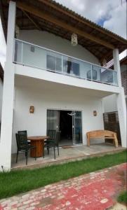 ein Haus mit einer Terrasse mit Tisch und Stühlen in der Unterkunft Paraíso Barra Grande in Barra Grande
