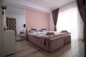 - une chambre avec un grand lit et une grande fenêtre dans l'établissement Happy Residence Sibiu, à Sibiu