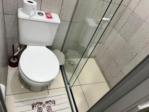 a bathroom with a toilet and a glass shower at Tia Preta Pousada in Morro de São Paulo