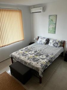 1 dormitorio con 1 cama con edredón de flores en Gorgeous, 3 Bed Villa at Bay View Villas, en Kosharitsa