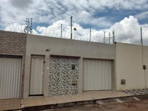 a building with four garages on the side of it at Casa mobiliada de 2 quartos na R Oliveira Alves Fontes, 609 E 603 - Jardim Gonzaga in Juazeiro do Norte