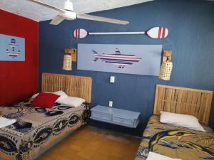 - une chambre avec 2 lits et une peinture sur un bateau dans l'établissement Hotel El Paraíso, à Armería