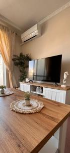 sala de estar con TV grande y mesa de madera en Nautilus Hygge Home, en Torrevieja