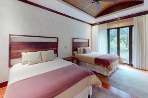 um quarto com 2 camas e uma grande janela em Pinilla Flor de Malinche 15 em Tamarindo