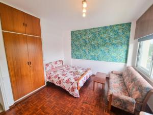 a living room with a couch and a bed at Larnaca Garden Rooms in Larnaka