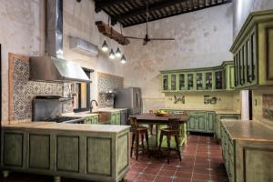 una cocina con armarios verdes y una mesa. en Casa Clorinda, en Campeche