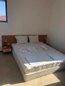 1 cama en un dormitorio con sábanas y almohadas blancas en Captivating, 1 Bedroom at Bay View Villas, en Kosharitsa
