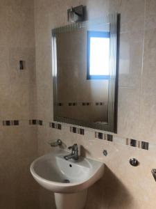 y baño con lavabo y espejo. en Captivating, 1 Bedroom at Bay View Villas, en Kosharitsa
