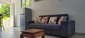 um sofá azul numa sala de estar com uma mesa em MON CHEZ MOI em Le Tampon