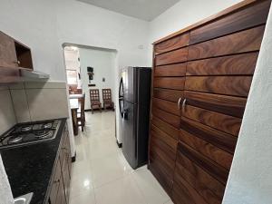 a kitchen with a refrigerator and a stove in it at Suite las palmas excelente depa con alberca in Manzanillo