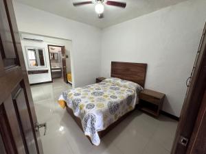 a bedroom with a bed and a ceiling fan at Suite las palmas excelente depa con alberca in Manzanillo
