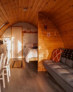 salon z kanapą i łóżkiem w pokoju w obiekcie Timber Valley Pods w mieście Galston