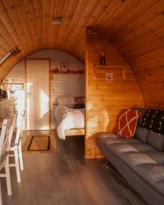 a living room with a couch and a bed in a room at Timber Valley Pods in Galston +20 photos