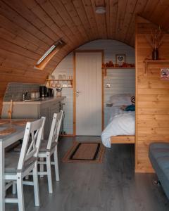 a room with a bed and a table and chairs at Timber Valley Pods in Galston