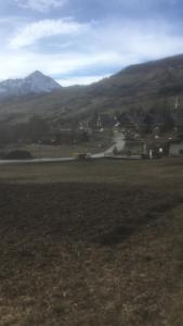 uma vista para um campo com uma montanha ao fundo em Villa millefiori falda argentera em Sauze di Cesana
