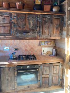 uma cozinha com armários de madeira e um forno com placa de fogão em Villa millefiori falda argentera em Sauze di Cesana