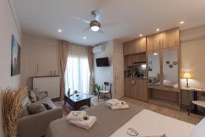 a living room with two beds and a couch at Kanela Apartment - Hellenic Apartments Avlona in Oinófita