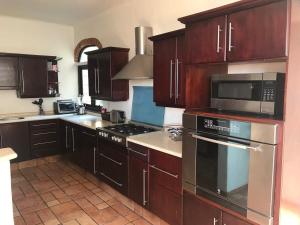 a kitchen with wooden cabinets and stainless steel appliances at Casa Quinta Joselito in Jiutepec