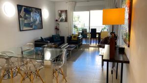 - un salon avec une table et des chaises en verre dans l'établissement appartement bord de mer 15 mn de Dénia, à El Verger