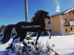 Una statua di un cavallo che corre nella neve di Ponyhof Adam Urlaub auf dem Bauernhof a Eschlkam