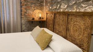 a bedroom with a bed with a pillow and a candle at SUITE HAUS BAHIA in Santander