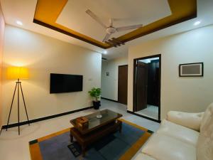 a living room with a couch and a tv at OWN IT - 2 bedroom apartment ORANGE in Islamabad