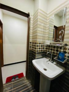 a bathroom with a sink and a mirror at OWN IT - 2 bedroom apartment ORANGE in Islamabad
