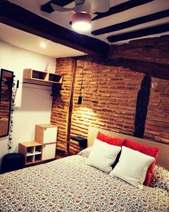 a bedroom with a bed and a brick wall at Holiday Duplex Casco Antiguo in Logroño