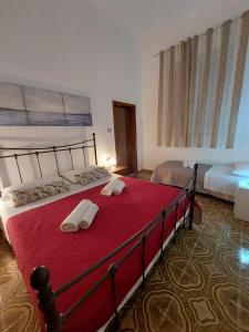 1 dormitorio con 1 cama con 2 toallas en Casa Carruvedda, en Avola