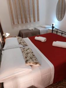 阿沃拉的住宿－Casa Carruvedda，红色和白色的客房内的两张床