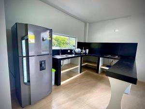 a kitchen with a refrigerator and a desk at Casa Campestre Villa de los Angeles in La Mesa