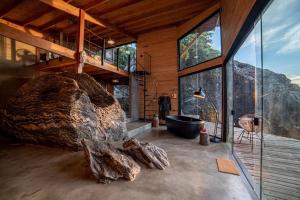 a bathroom with a large rock and a bath tub at Cabana Carcará in São Bento do Sapucaí