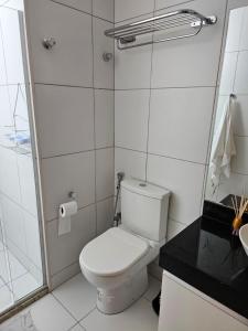 a white bathroom with a toilet and a shower at Iloa Residence Apt Premium -Quarto e sala climatizado in Barra de São Miguel