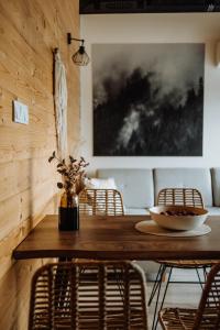 a dining room with a wooden table and chairs at Loft&Hill in Grywałd