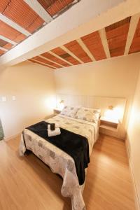 um quarto com uma cama grande e piso em madeira em Loft completo e aconchegante em Canela