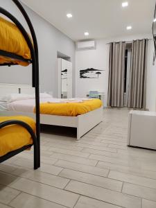 um quarto com 2 beliches com lençóis amarelos em Eleonora's Home em Nápoles