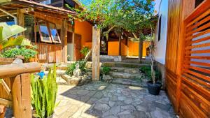 une cour avec des arbres et des plantes dans une maison dans l'établissement Vila no Rosa Hospedaria, à Praia do Rosa