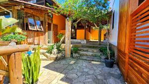 a courtyard with trees and plants in a house at Vila no Rosa Hospedaria in Praia do Rosa