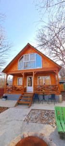 a large wooden house with a picnic table in front of it at Wooden House Kopiti in Tbilisi City +18 photos